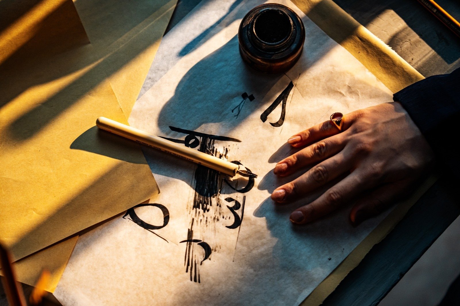 Arabic calligraphy being created by hand during development of the CCQ identity